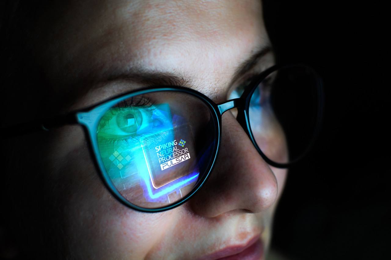 Bild zeigt eine Frau mit großer Brille, bei der ein Computerchip spiegelt