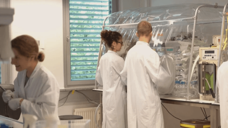 Das Bildmotiv zeigt drei Menschen in einem Labor von mbiomics