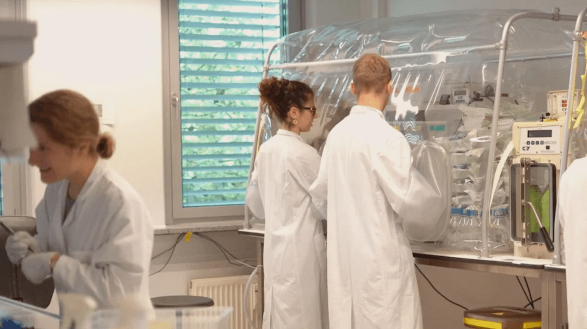Das Bildmotiv zeigt drei Menschen in einem Labor von mbiomics